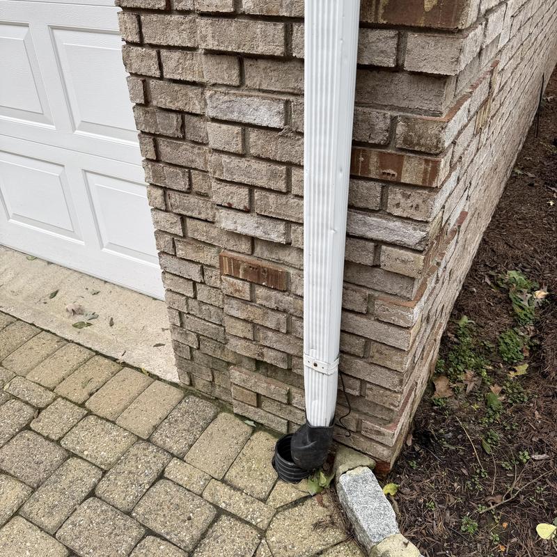 Downspout drainage pipe at brick house corner Downspout drainage pipe at brick house corner