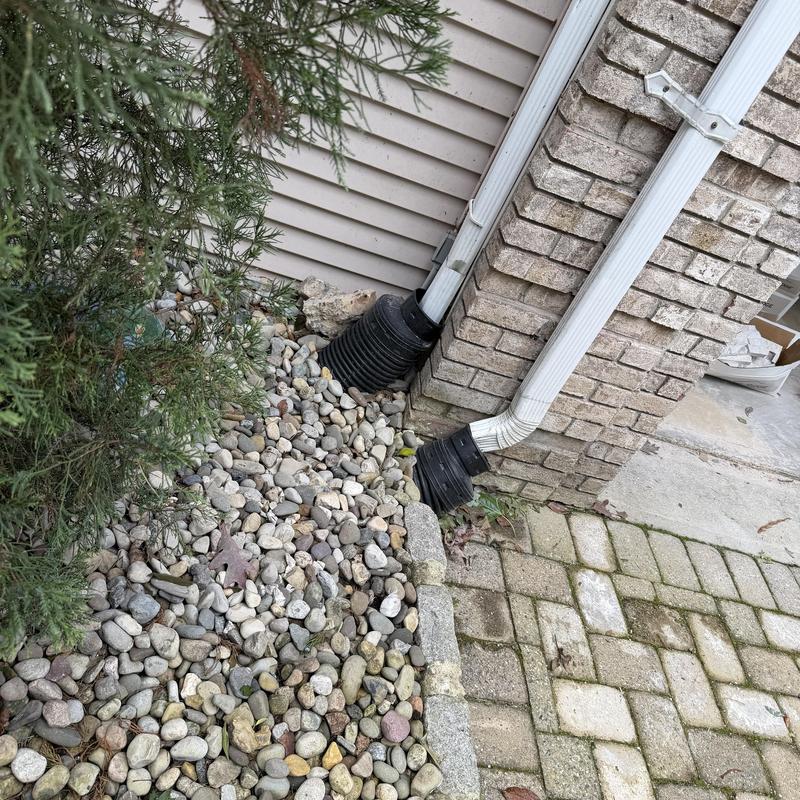 Downspout drain pipes with gravel bed near foundation Downspout drain pipes with gravel bed near foundation