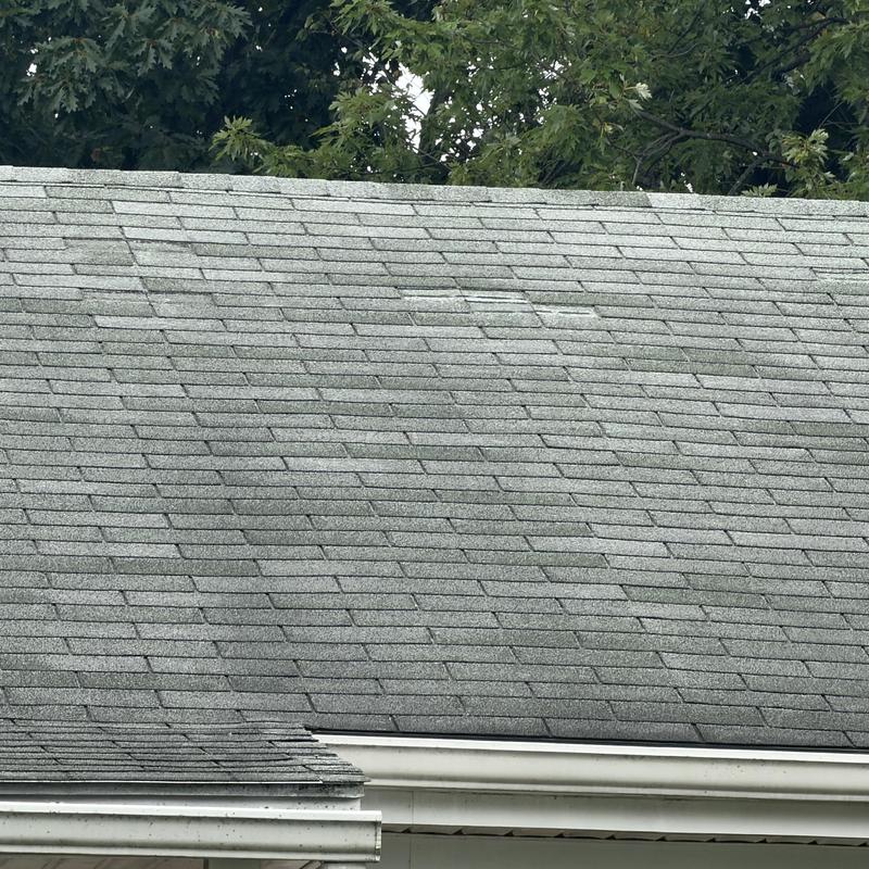 Asphalt shingle roof with wind damage and wear Asphalt shingle roof with wind damage and wear