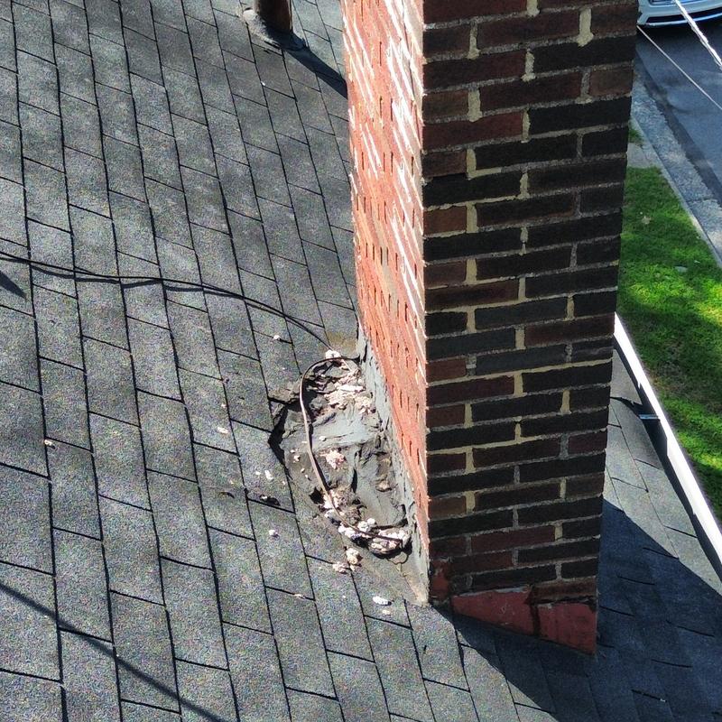 Chimney flashing with deteriorated sealant on shingle roof Chimney flashing with deteriorated sealant on shingle roof