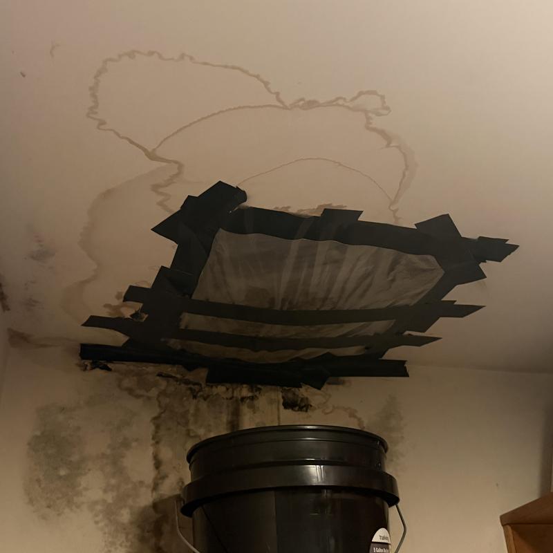 Ceiling water damage with taped plastic patch Ceiling water damage with taped plastic patch