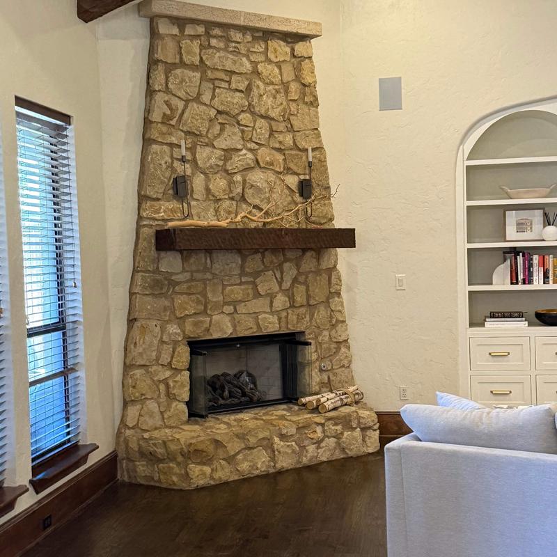 Stone fireplace with wooden mantle in living room Stone fireplace with wooden mantle in living room