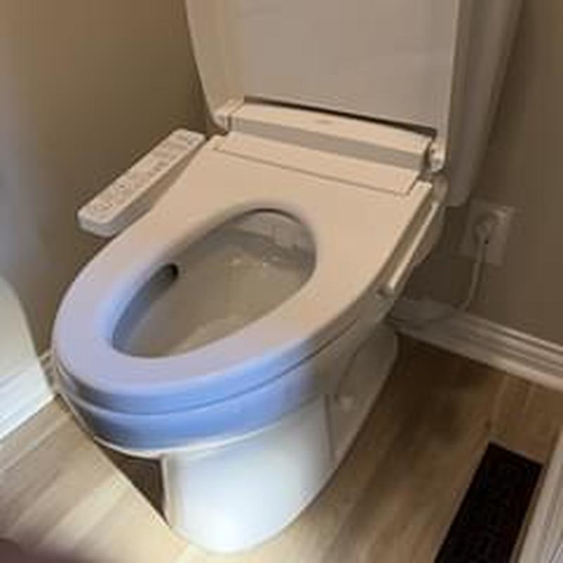 Toilet with bidet seat installation in bathroom corner