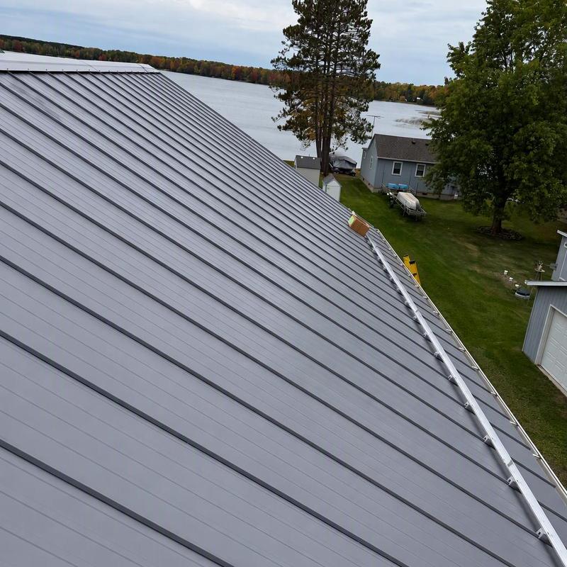 Standing-seam steel roof with snow retention system