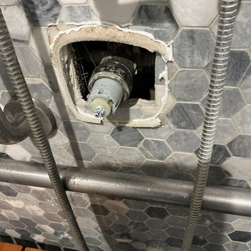 Shower cartridge exposed in tiled shower wall repair