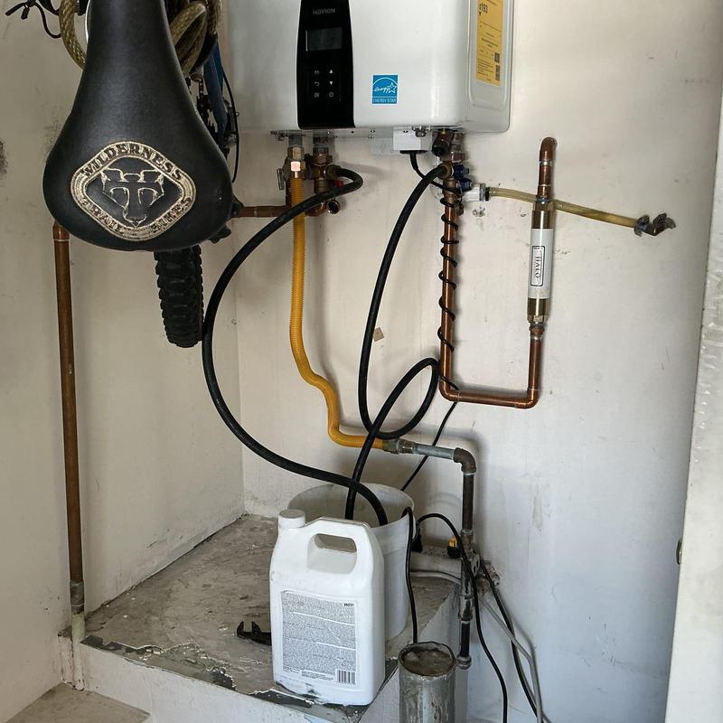 Tankless water heater with descaling setup and piping