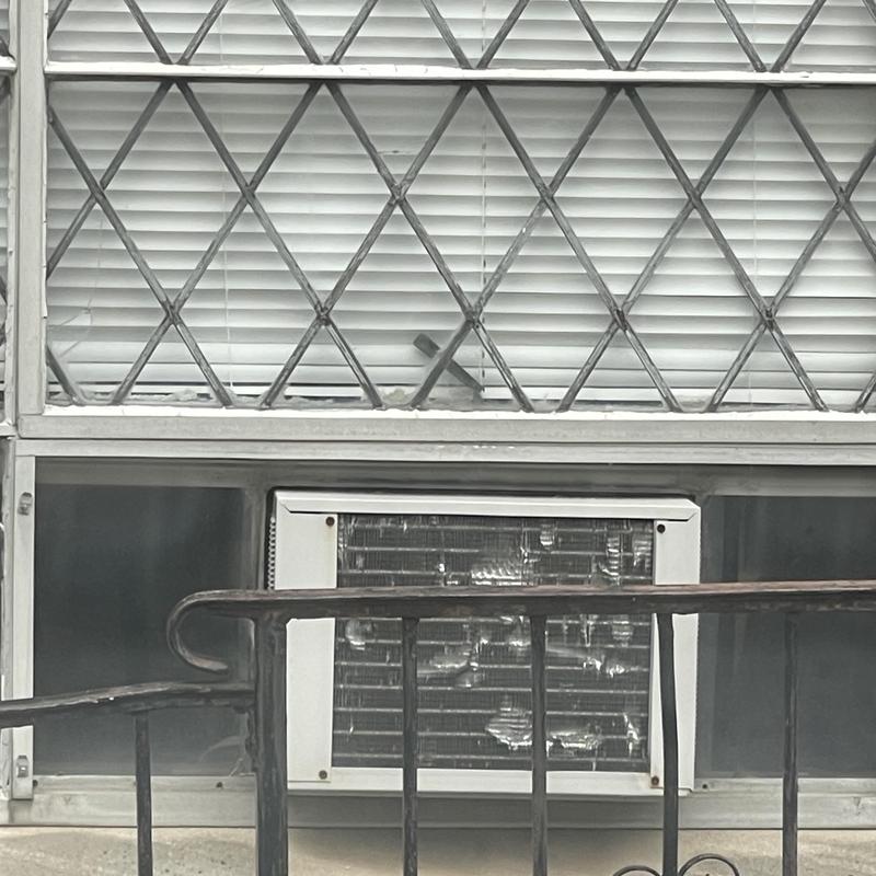 Window air conditioner with metal security bars and blinds