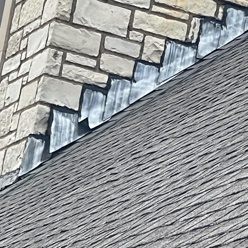 Roof flashing installation on stone chimney edge
