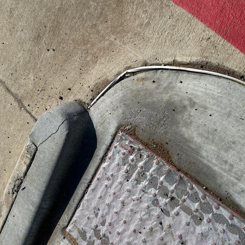 Concrete curb and sidewalk corner with damage and debris Concrete curb and sidewalk corner with damage and debris