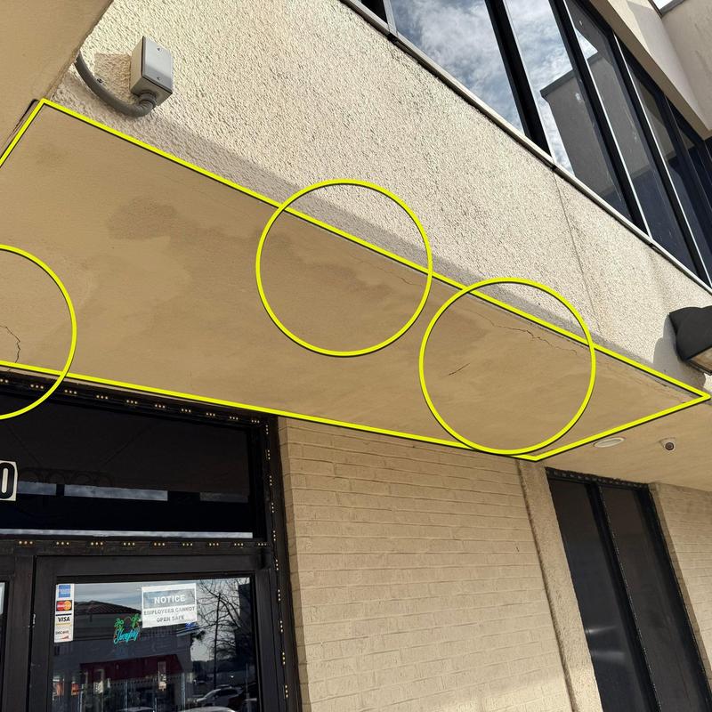 Concrete canopy with aging cracks and stains at commercial building Concrete canopy with aging cracks and stains at commercial building