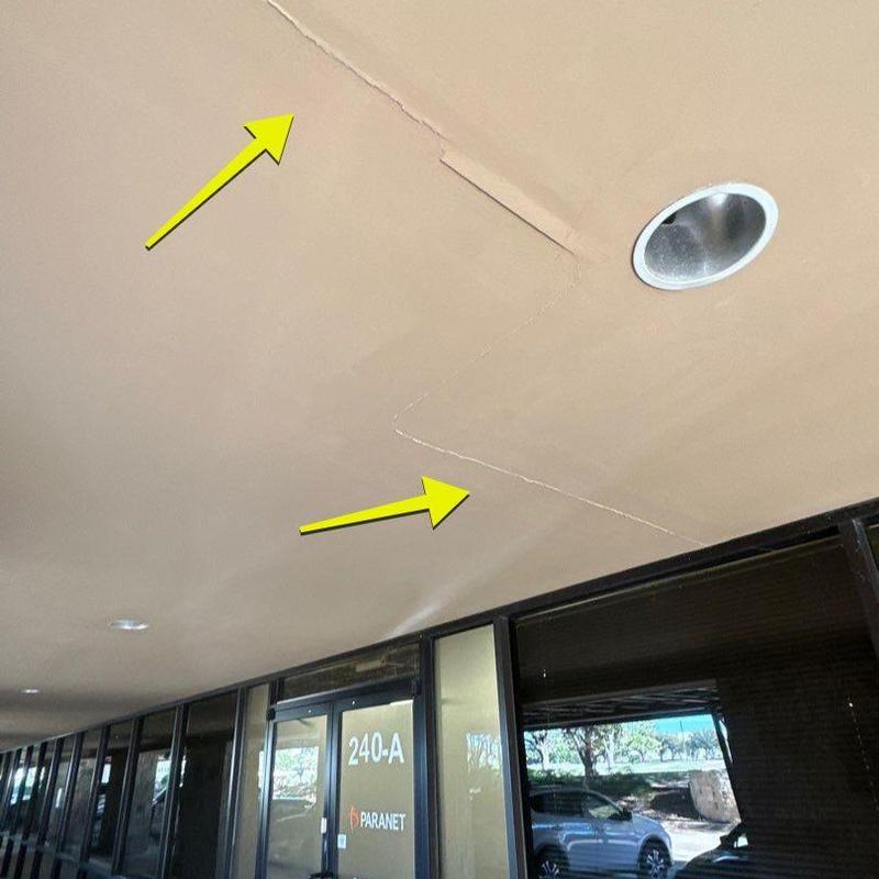 Stucco ceiling with cracks near commercial doors Stucco ceiling with cracks near commercial doors