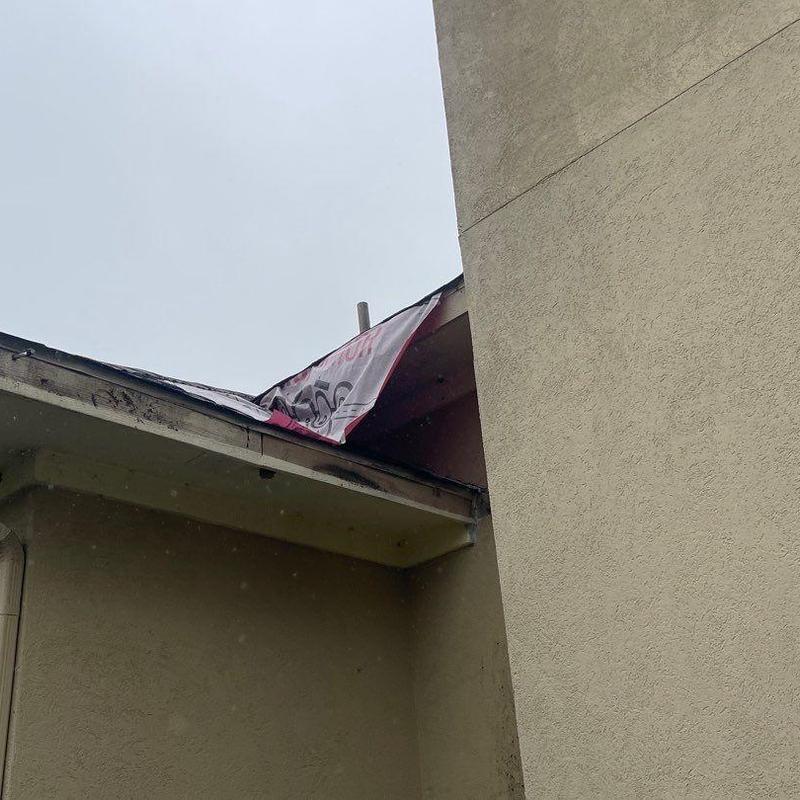Roof edge and soffit with torn underlayment exposed Roof edge and soffit with torn underlayment exposed