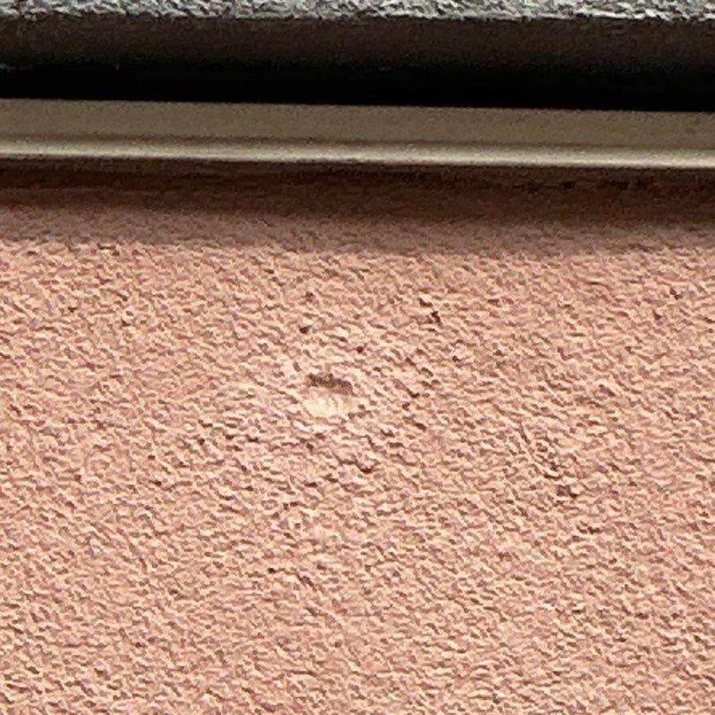 Stucco wall with small surface dent under eave Stucco wall with small surface dent under eave