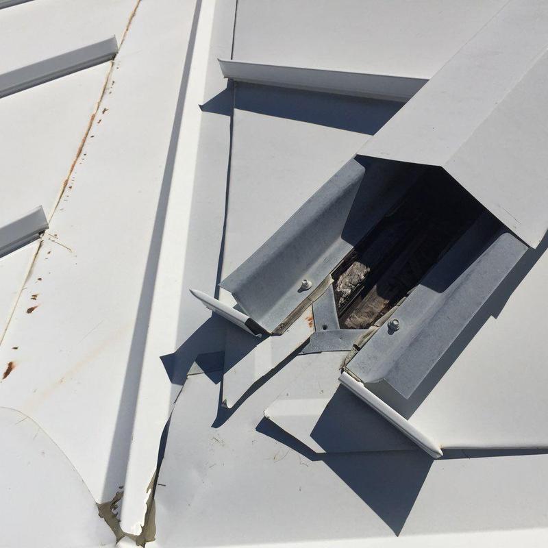 Metal roof damaged vent flashing on commercial building
