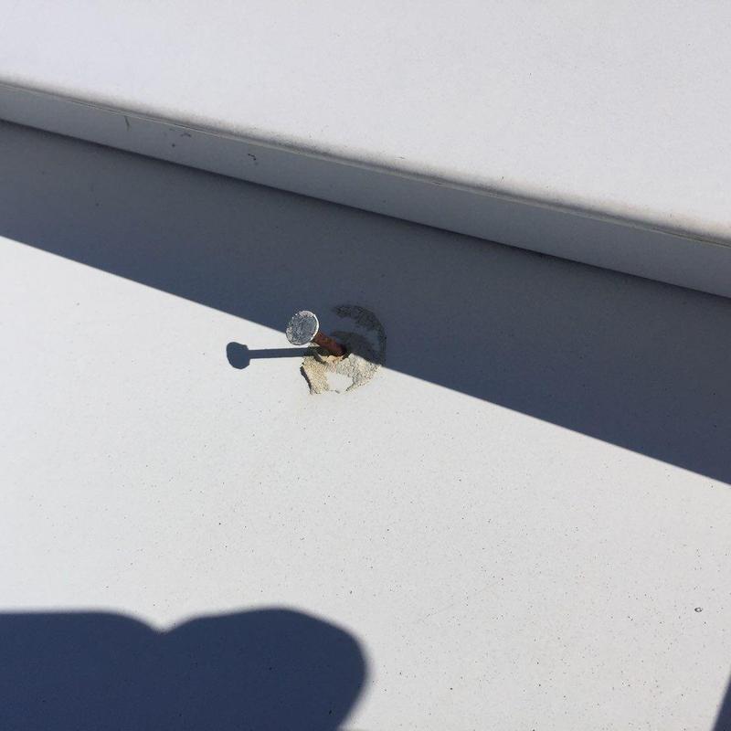 Metal roofing nail with damaged sealant patch