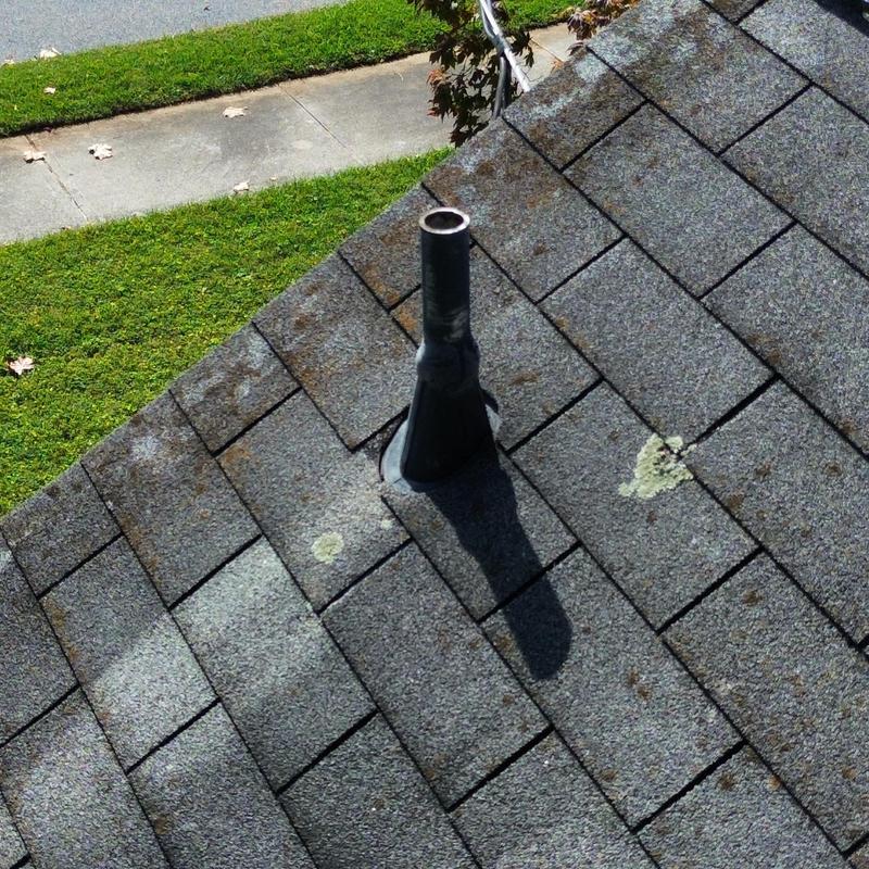 Roof vent flashing on shingled roof with moss and lichen Roof vent flashing on shingled roof with moss and lichen