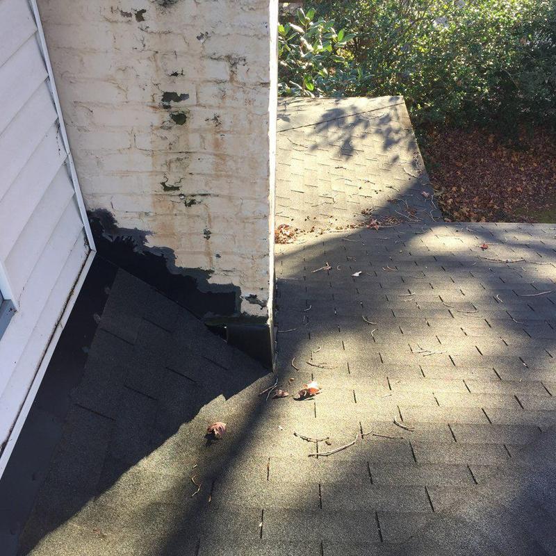 Chimney flashing with charcoal-gray shingles on roof
