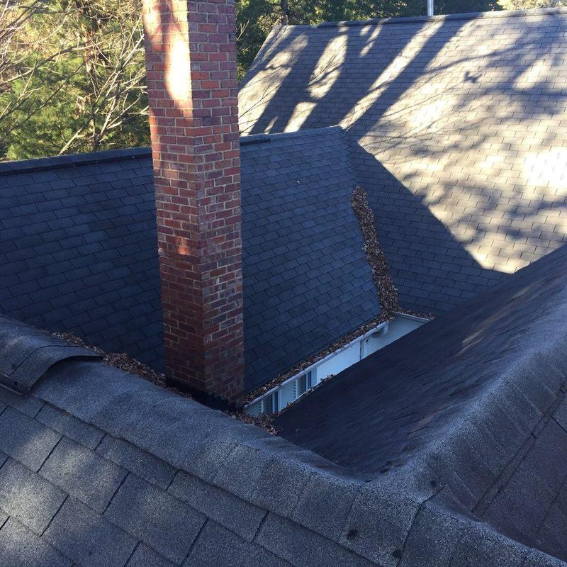 Chimney flashing and charcoal-gray shingle roof sections