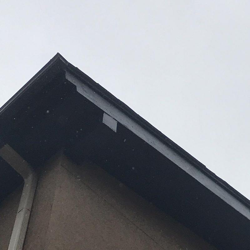 Shingle roofing edge and gutter at condo exterior