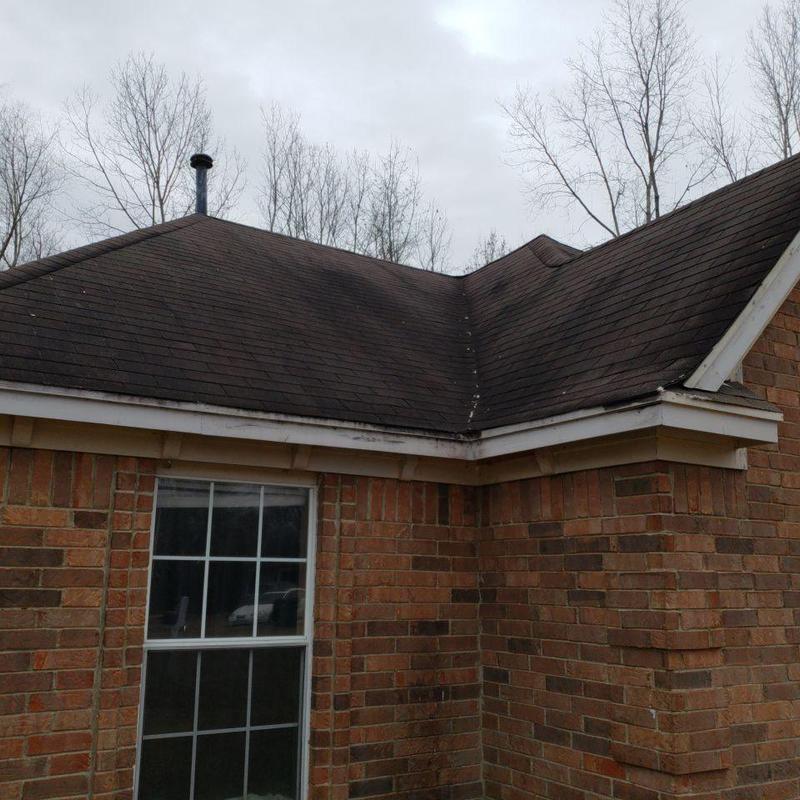 Asphalt shingle roof with storm damage on brick house
