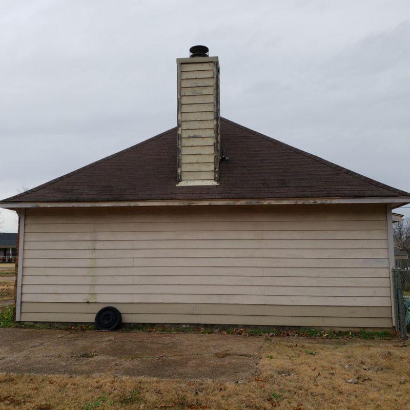 Asphalt shingle roof with chimney on house exterior