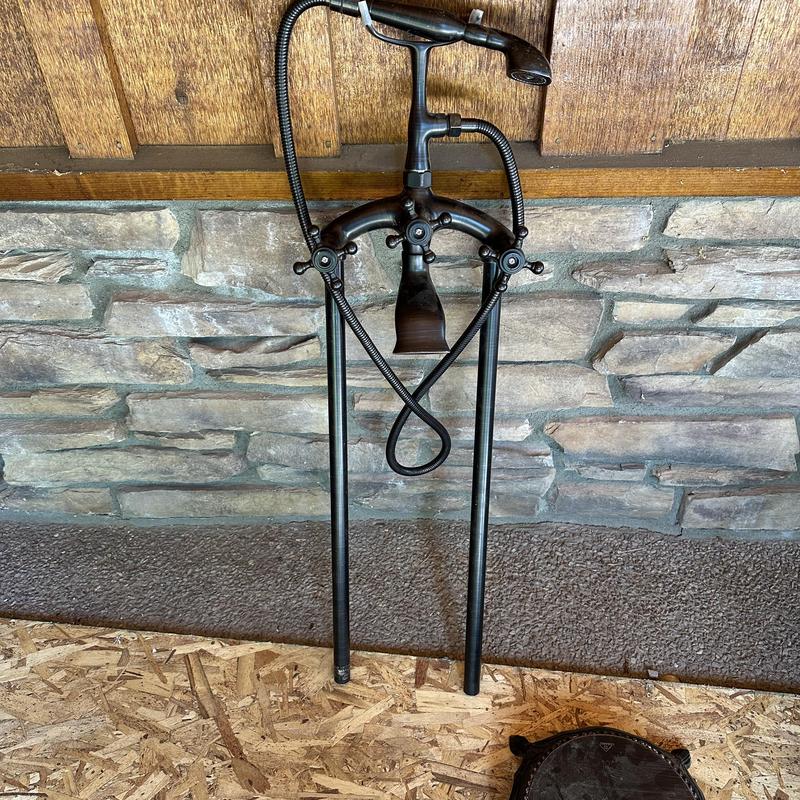 Tub filler valve with hand shower on plywood floor Tub filler valve with hand shower on plywood floor