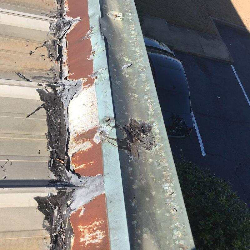 Metal roof flashing with storm damage and sealant repairs