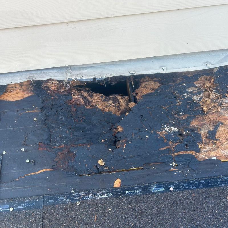 Shingle roof with storm damage and wood rot hole Shingle roof with storm damage and wood rot hole