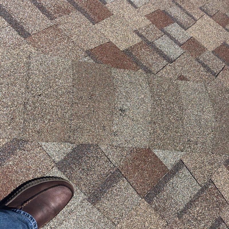 Asphalt roof shingles with foot for scale Asphalt roof shingles with foot for scale