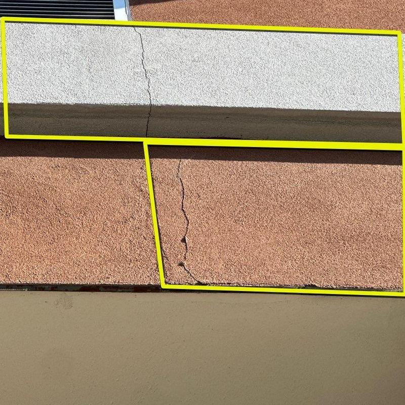 Concrete wall with stucco crack repair areas highlighted Concrete wall with stucco crack repair areas highlighted