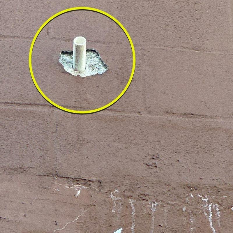 Concrete wall with chipped stucco and pipe exposure Concrete wall with chipped stucco and pipe exposure