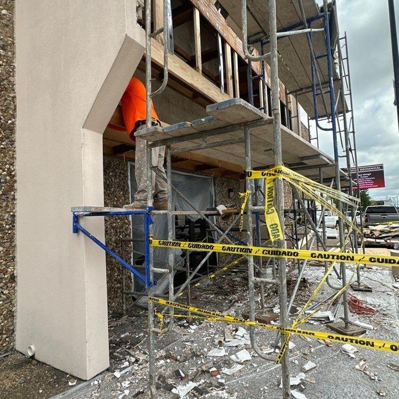 Concrete wall damage repair with scaffolding and caution tape Concrete wall damage repair with scaffolding and caution tape