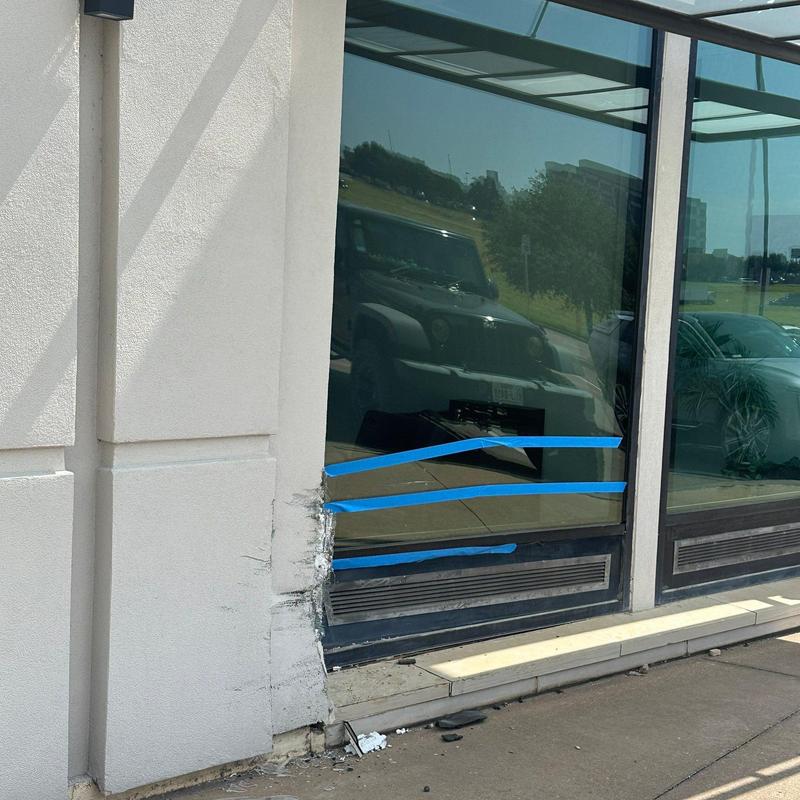 Stucco wall damage beside glass storefront window Stucco wall damage beside glass storefront window