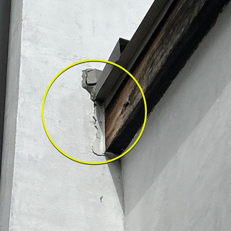 Stucco wall damage near roof edge with wood exposure Stucco wall damage near roof edge with wood exposure