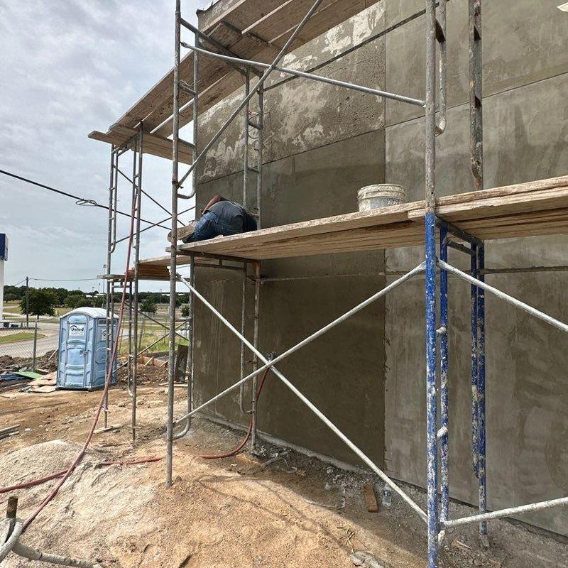 Concrete exterior wall application on scaffolding Concrete exterior wall application on scaffolding