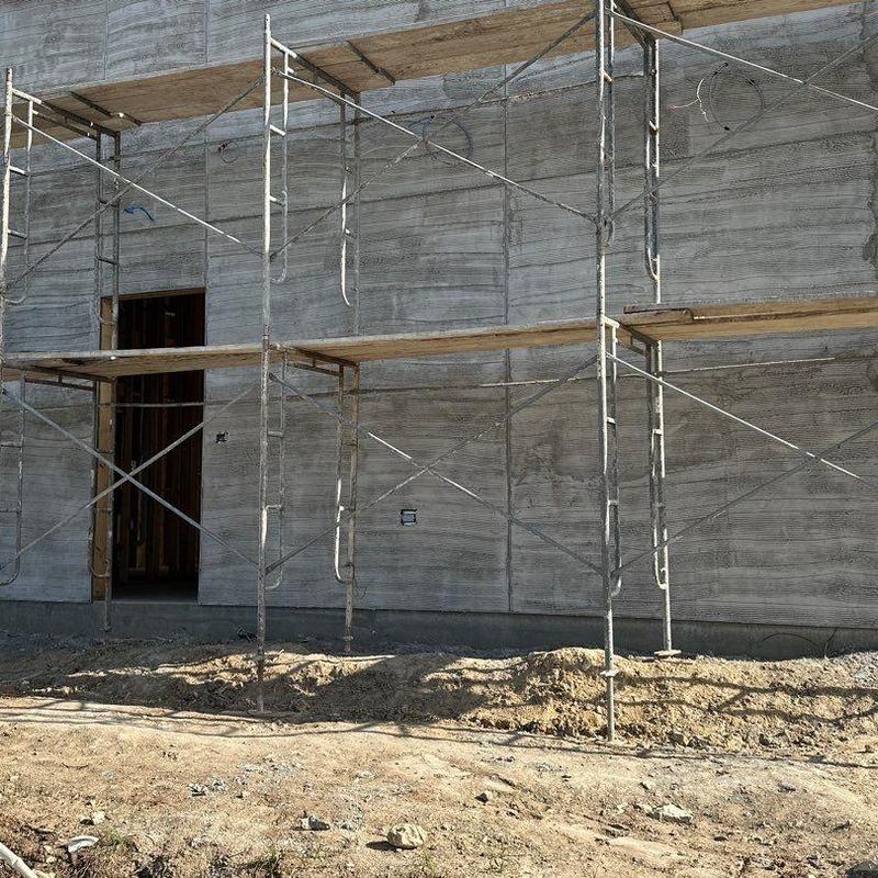 Concrete exterior wall with scaffolding at construction site Concrete exterior wall with scaffolding at construction site