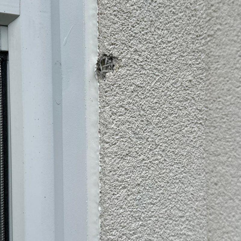 Stucco wall damage near window frame close-up detail Stucco wall damage near window frame close-up detail