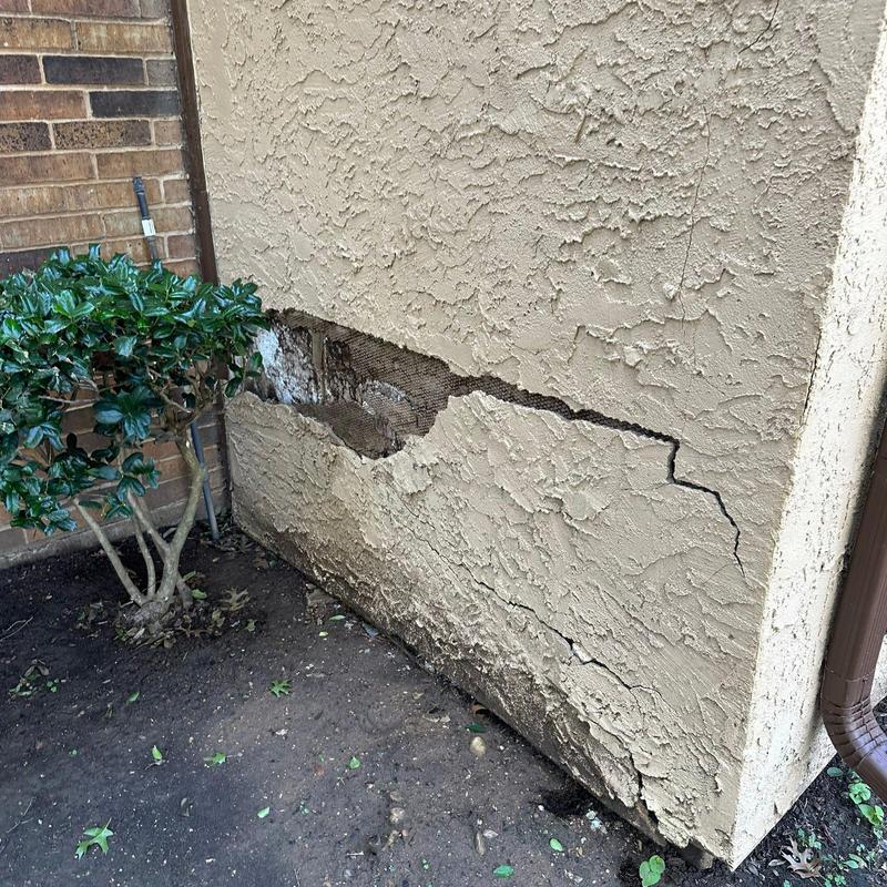 Stucco wall with cracked and damaged lower section Stucco wall with cracked and damaged lower section