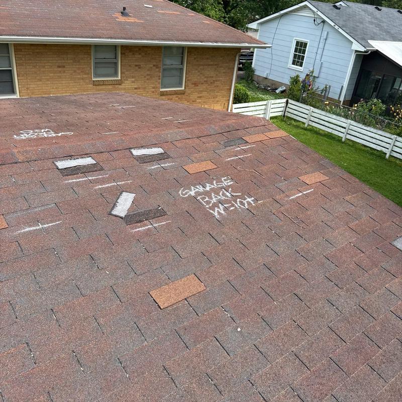 Asphalt roof shingles with hail damage marked for repair