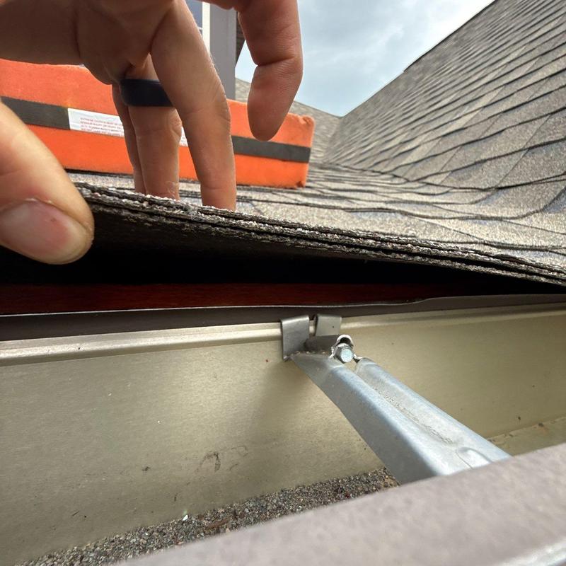 Asphalt shingle roof edge inspection near gutter system