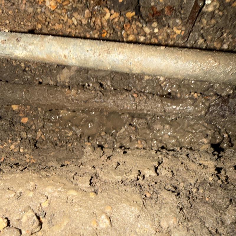Water line with leak under house in muddy soil Water line with leak under house in muddy soil