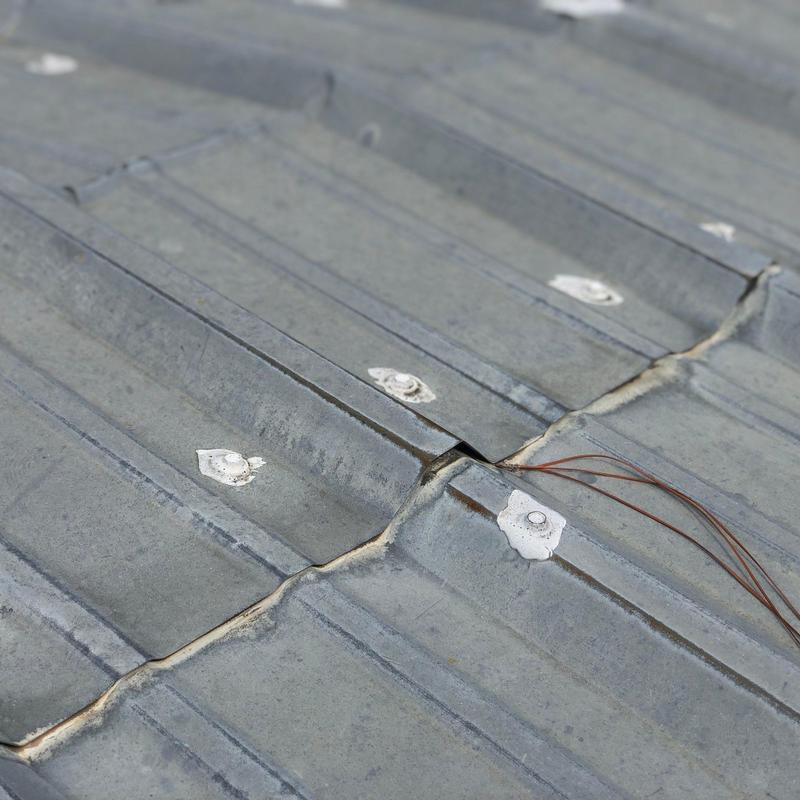 Metal roofing with sealed screws and wire attachments Metal roofing with sealed screws and wire attachments