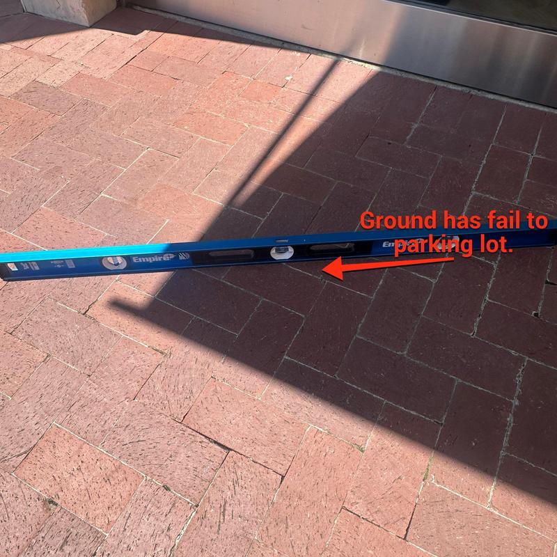 Brick floor leveling check with spirit level and shadow Brick floor leveling check with spirit level and shadow