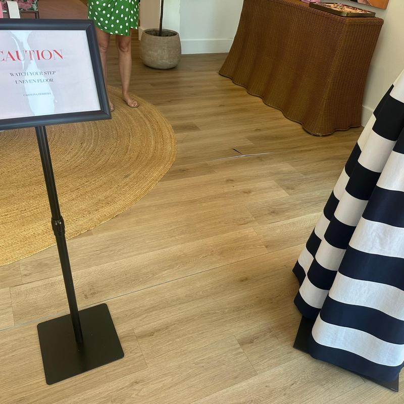Wood floor with uneven plank lifting warning sign Wood floor with uneven plank lifting warning sign