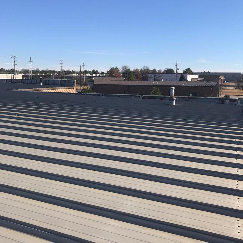 Metal roof with flashing and vent pipe on industrial building
