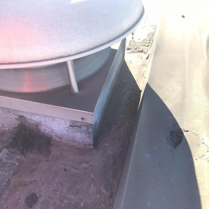Metal roof vent flashing and sealant on flat roof