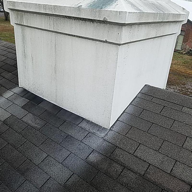 Architectural asphalt shingle roof with white chimney base