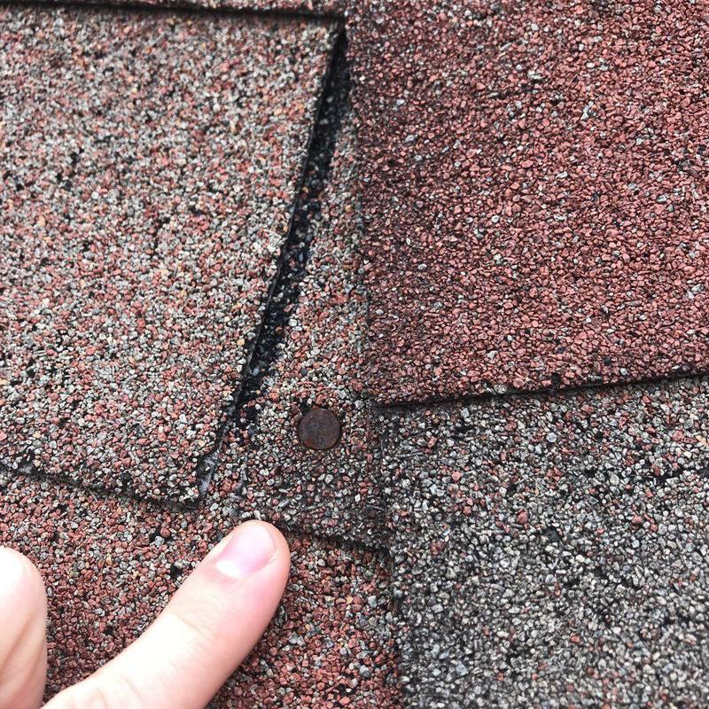 Architectural roof shingles showing damage and lifting