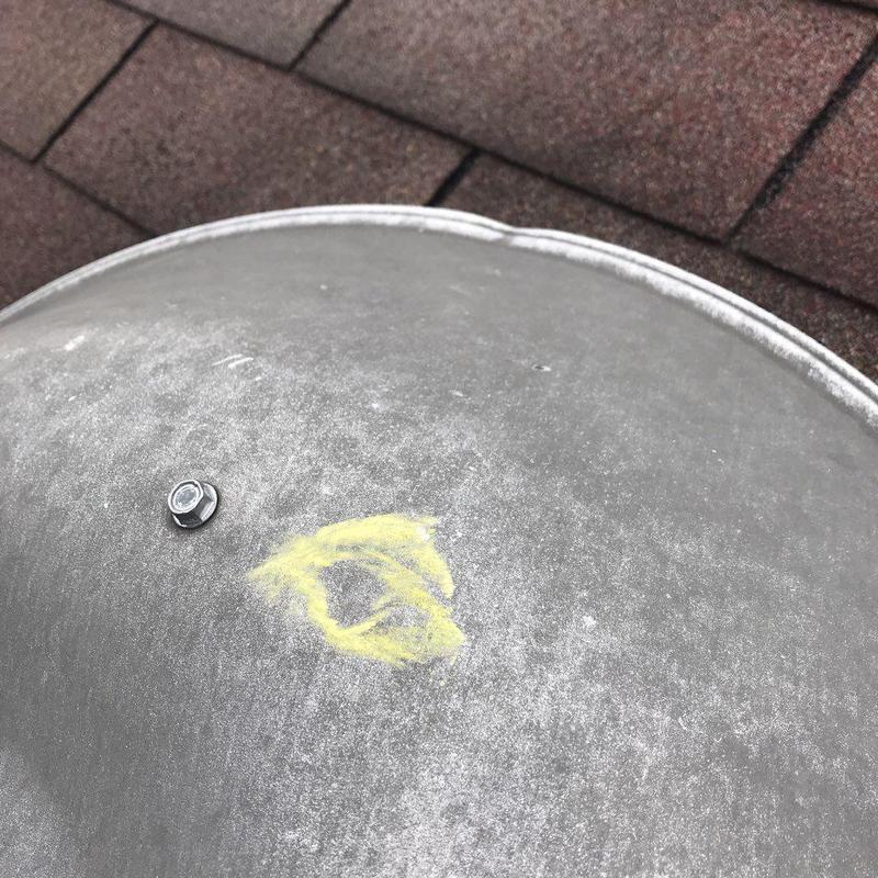 Metal roof vent with yellow chalk marking near shingles