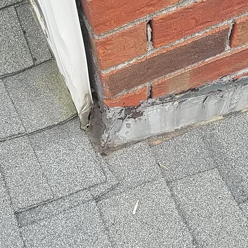 Chimney flashing and shingle roof detail with repairs